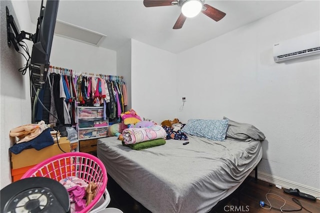 1089 E Columbia Ave, Pomona, CA 91767 - bedroom with wood finished floors, baseboards, a wall unit AC, a ceiling fan, and attic access