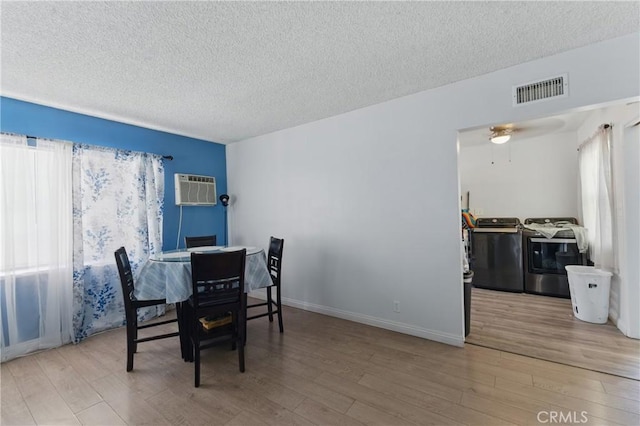 1089 E Columbia Ave, Pomona, CA 91767 - dining room with washing machine and clothes dryer, a wall mounted air conditioner, a textured ceiling, and wood finished floors