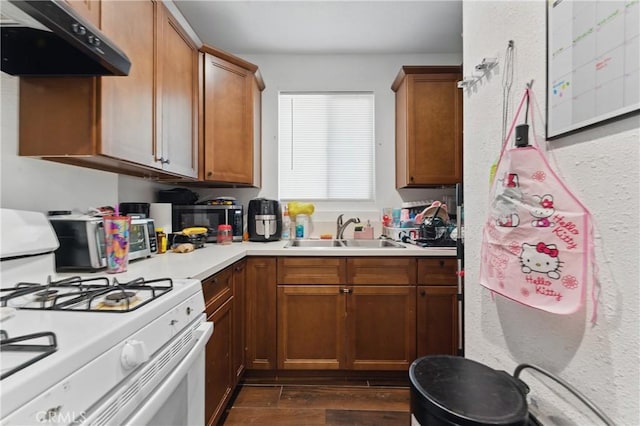 1089 E Columbia Ave, Pomona, CA 91767 - kitchen with white gas range, a sink, under cabinet range hood, and light countertops