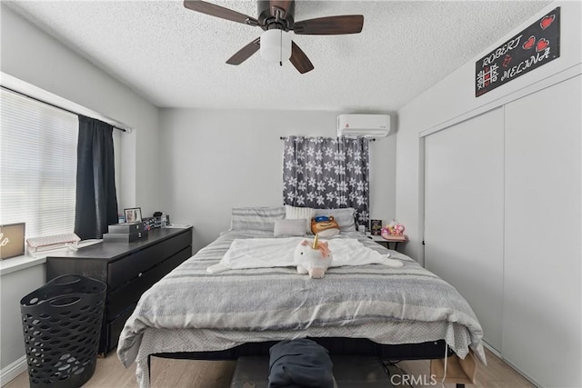 1089 E Columbia Ave, Pomona, CA 91767 - bedroom with a wall mounted AC, a textured ceiling, wood finished floors, ceiling fan, and a closet
