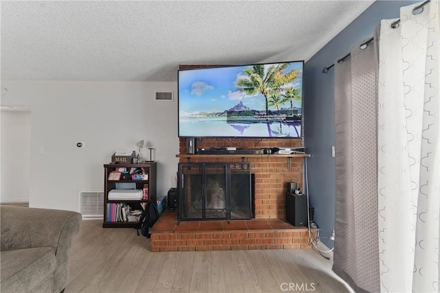1089 E Columbia Ave, Pomona, CA 91767 - living room featuring wood finished floors, a textured ceiling, and a fireplace