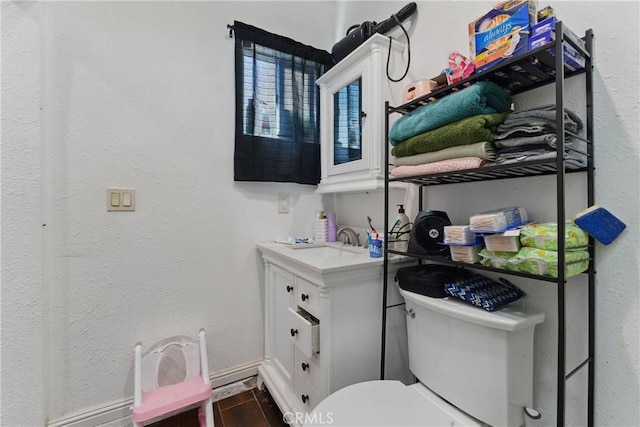 1089 E Columbia Ave, Pomona, CA 91767 - bathroom with toilet, vanity, wood finished floors, and a textured wall