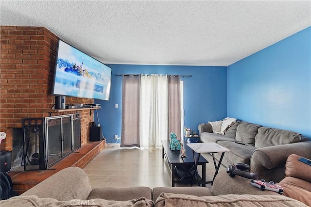 1089 E Columbia Ave, Pomona, CA 91767 - living area with a brick fireplace, a textured ceiling, wood finished floors, and baseboards