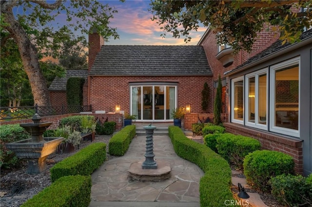 4275 Country Club Dr, Long Beach, CA 90807 - back of property at dusk with brick siding and a chimney
