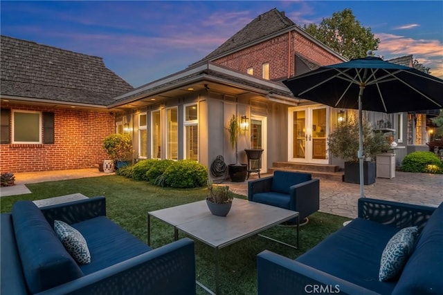 4275 Country Club Dr, Long Beach, CA 90807 - back of property at dusk featuring an outdoor living space, brick siding, french doors, a patio area, and a yard