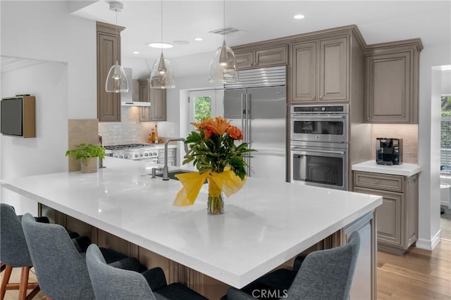 4275 Country Club Dr, Long Beach, CA 90807 - kitchen featuring stainless steel appliances, decorative backsplash, a breakfast bar area, and recessed lighting