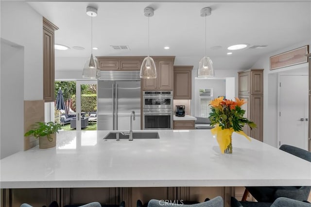 4275 Country Club Dr, Long Beach, CA 90807 - kitchen featuring appliances with stainless steel finishes, a kitchen breakfast bar, a sink, tasteful backsplash, and a peninsula