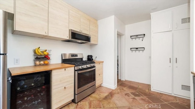 686 W 34th St, San Bernardino, CA 92405 - kitchen with stainless steel appliances, wine cooler, butcher block counters, light stone finish floors, and light brown cabinets