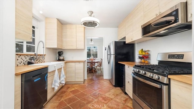 686 W 34th St, San Bernardino, CA 92405 - kitchen with appliances with stainless steel finishes, butcher block counters, a sink, and light brown cabinetry