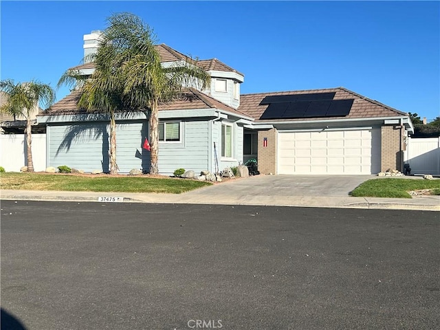 37475 Cole Creek Ct, Murrieta, CA 92562 - view of front facade featuring solar panels, a garage, brick siding, concrete driveway, and a chimney
