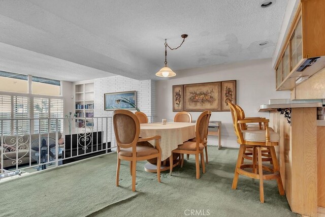 5348 Fairview Blvd Unit 3, Ladera Heights, CA 90056 - dining space featuring a textured ceiling, carpet floors, a fireplace, and built in shelves