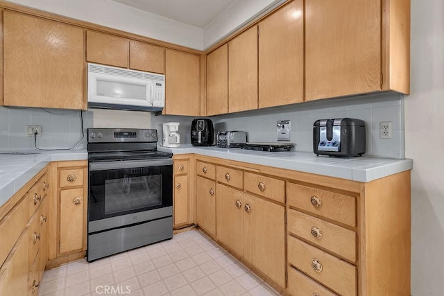 5348 Fairview Blvd Unit 3, Ladera Heights, CA 90056 - kitchen featuring white microwave, electric range, tile countertops, and decorative backsplash