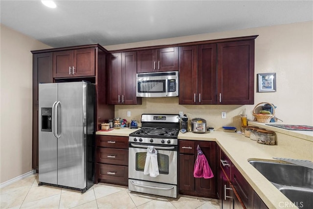 1441 Brett Pl Unit 136, San Pedro, CA 90732 - kitchen featuring stainless steel appliances, reddish brown cabinets, light countertops, a sink, and light tile patterned floors