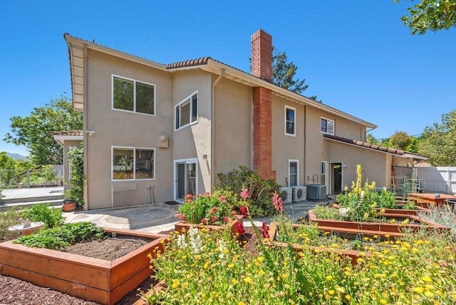 14040 Old Station Rd, San Diego, CA 92064 - rear view of house featuring a garden, a chimney, stucco siding, and central AC