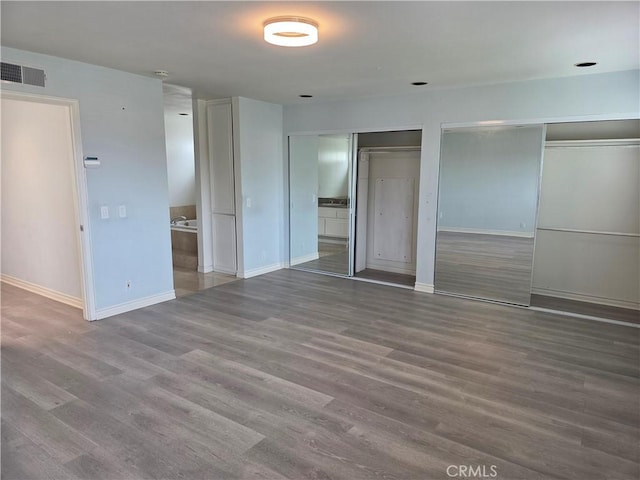 2937 Oakwood Ln, Torrance, CA 90505 - unfurnished bedroom featuring two closets, baseboards, and wood finished floors