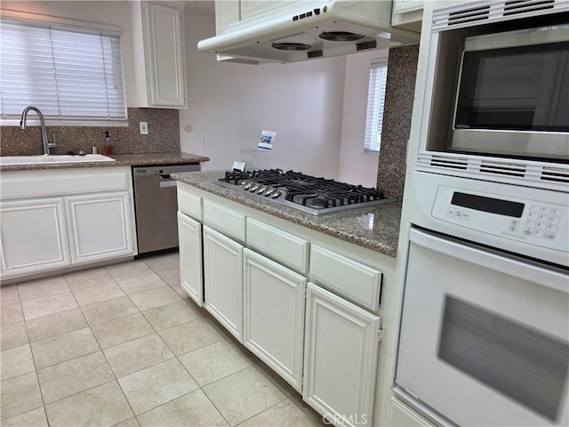 2937 Oakwood Ln, Torrance, CA 90505 - kitchen with stainless steel appliances, under cabinet range hood, backsplash, a sink, and light tile patterned flooring