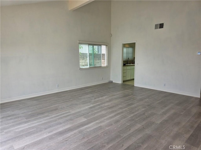 2937 Oakwood Ln, Torrance, CA 90505 - unfurnished room featuring a towering ceiling, a sink, dark wood-type flooring, and baseboards