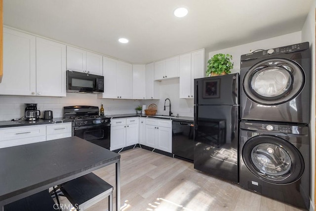 42692 Moonridge Rd, Big Bear Lake, CA 92315 - kitchen featuring black appliances, stacked washer / drying machine, a sink, dark countertops, and white cabinets