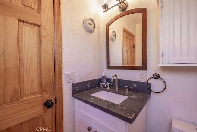 42692 Moonridge Rd, Big Bear Lake, CA 92315 - half bathroom with vanity, a textured wall, and toilet