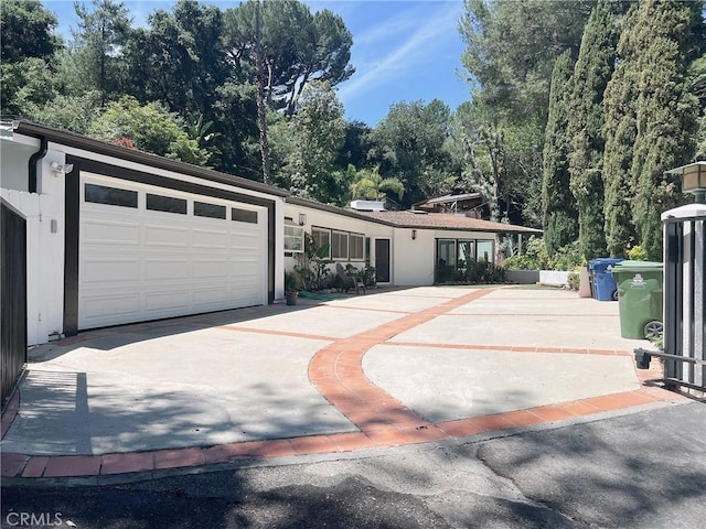 9466 Hidden Valley Pl, Beverly Hills, CA 90210 - view of front of house featuring concrete driveway, an attached garage, and stucco siding