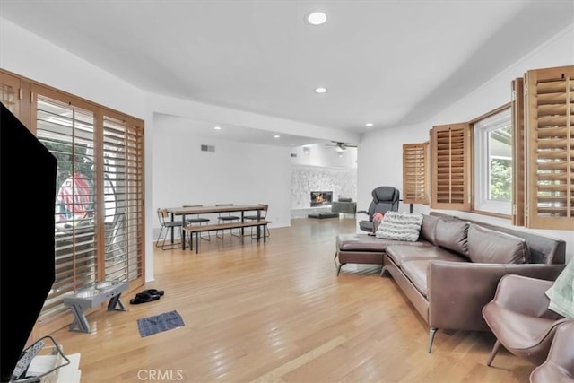 9466 Hidden Valley Pl, Beverly Hills, CA 90210 - living area with healthy amount of natural light, a ceiling fan, a glass covered fireplace, light wood-style floors, and recessed lighting