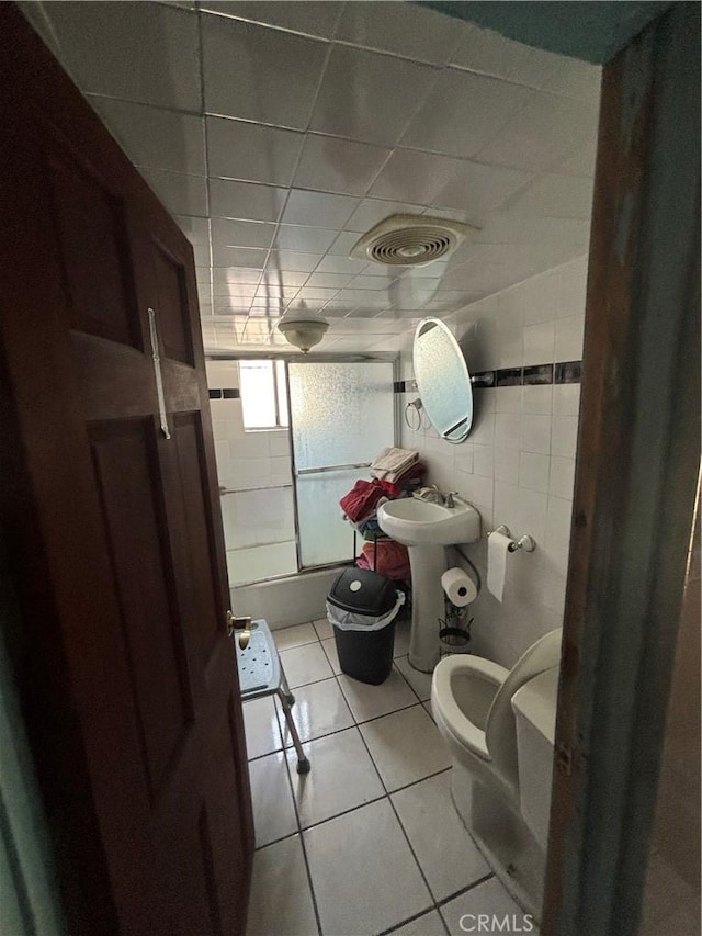223 E 28th St, Los Angeles, CA 90011 - bathroom featuring a sink, toilet, tile patterned flooring, and tile walls