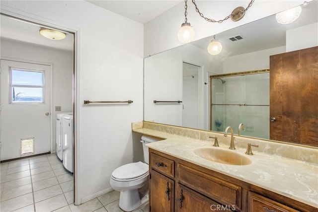 4256 Mockingbird Ln, Banning, CA 92220 - full bath with separate washer and dryer, toilet, vanity, a shower with shower door, and tile patterned floors