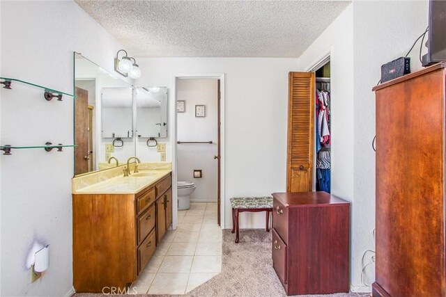 4256 Mockingbird Ln, Banning, CA 92220 - bathroom with toilet, a textured ceiling, vanity, and tile patterned floors