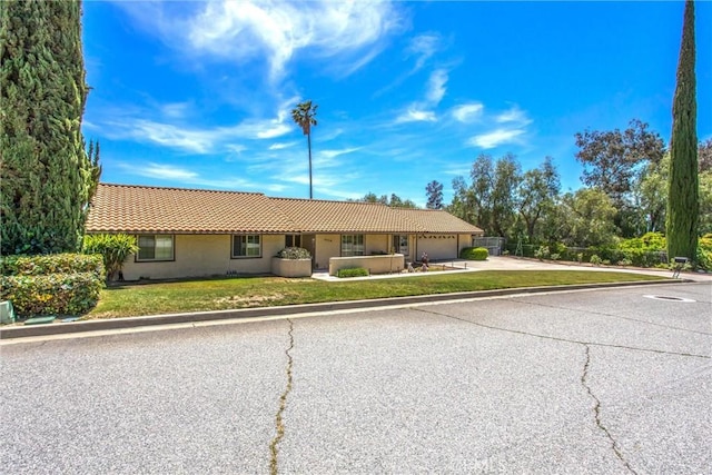 4256 Mockingbird Ln, Banning, CA 92220 - ranch-style home with a tile roof, a garage, driveway, and stucco siding