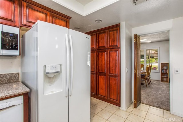 4256 Mockingbird Ln, Banning, CA 92220 - kitchen featuring white appliances, light tile patterned floors, a textured ceiling, light carpet, and reddish brown cabinets