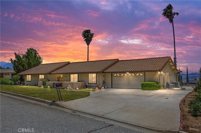 4256 Mockingbird Ln, Banning, CA 92220 - view of front of property featuring a tiled roof, an attached garage, concrete driveway, a gate, and stucco siding