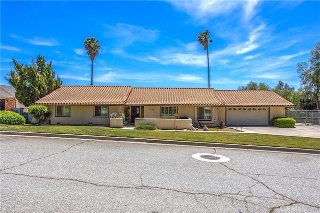 4256 Mockingbird Ln, Banning, CA 92220 - ranch-style house with a tiled roof, an attached garage, stucco siding, and driveway