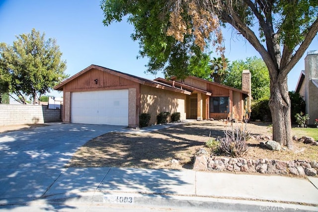 1003 Lightcap St, Lancaster, CA 93535 - view of front of home featuring driveway, an attached garage, and a chimney