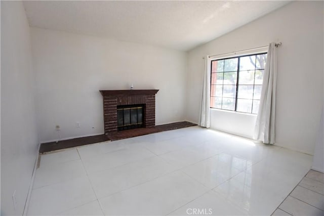1003 Lightcap St, Lancaster, CA 93535 - unfurnished living room with lofted ceiling, a brick fireplace, tile patterned flooring, and baseboards