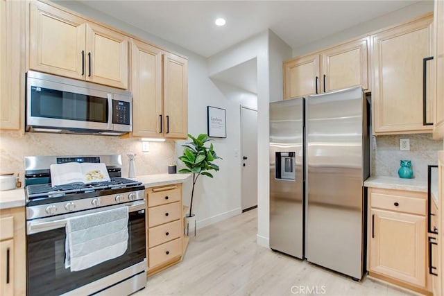 28210 Canterbury Ct, Valencia, CA 91354 - kitchen featuring appliances with stainless steel finishes, light brown cabinetry, light wood-style flooring, tasteful backsplash, and recessed lighting