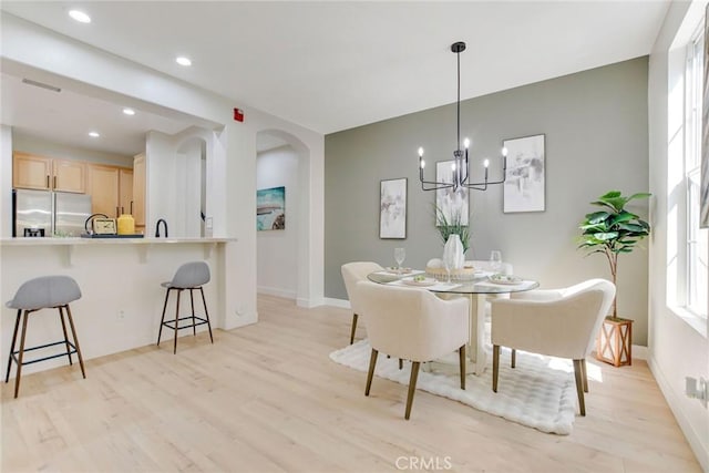 28210 Canterbury Ct, Valencia, CA 91354 - dining room featuring arched walkways, light wood finished floors, a chandelier, recessed lighting, and baseboards
