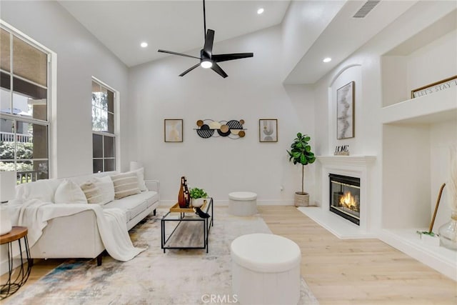 28210 Canterbury Ct, Valencia, CA 91354 - living area featuring wood finished floors, a glass covered fireplace, a ceiling fan, recessed lighting, and vaulted ceiling