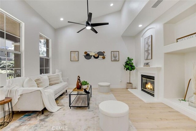 28210 Canterbury Ct, Valencia, CA 91354 - living area with wood finished floors, a glass covered fireplace, ceiling fan, recessed lighting, and lofted ceiling