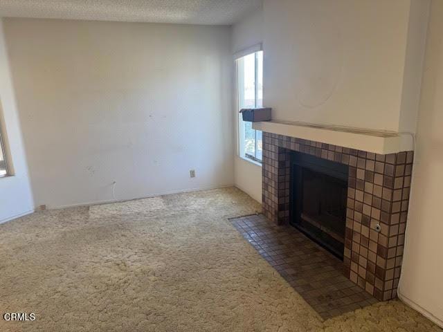 1742 Sinaloa Rd Unit 329, Simi Valley, CA 93065 - unfurnished living room featuring a fireplace, carpet flooring, and a textured ceiling