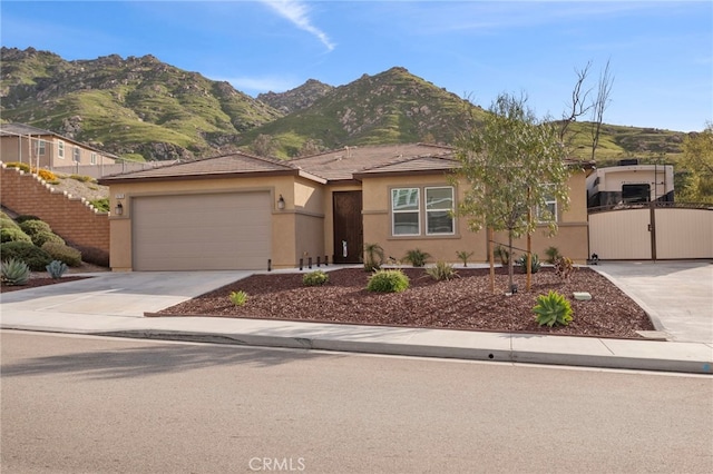 20793 Spring Mountain Rd, Riverside, CA 92507 - ranch-style house featuring stucco siding, a gate, a garage, driveway, and a mountain view