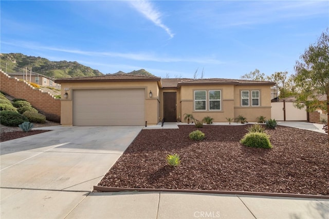 20793 Spring Mountain Rd, Riverside, CA 92507 - ranch-style house with stucco siding, a garage, concrete driveway, and a mountain view