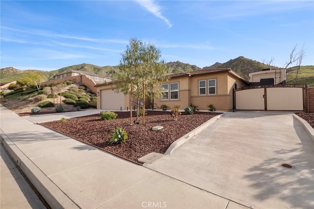 20793 Spring Mountain Rd, Riverside, CA 92507 - single story home with a mountain view, a gate, stucco siding, and an attached garage