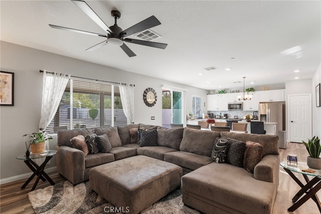 20793 Spring Mountain Rd, Riverside, CA 92507 - living room featuring wood finished floors, a chandelier, ceiling fan, baseboards, and recessed lighting