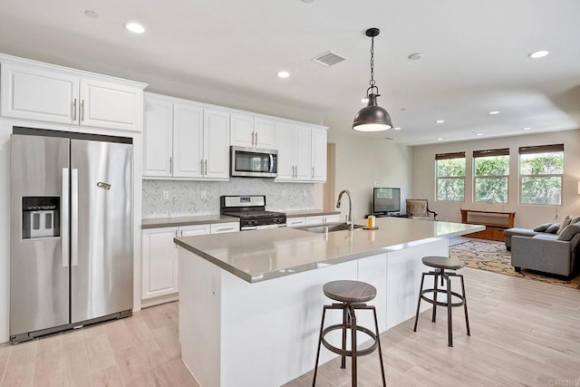 678 Gemstone Dr, San Marcos, CA 92078 - kitchen featuring appliances with stainless steel finishes, open floor plan, a sink, light wood-type flooring, and recessed lighting