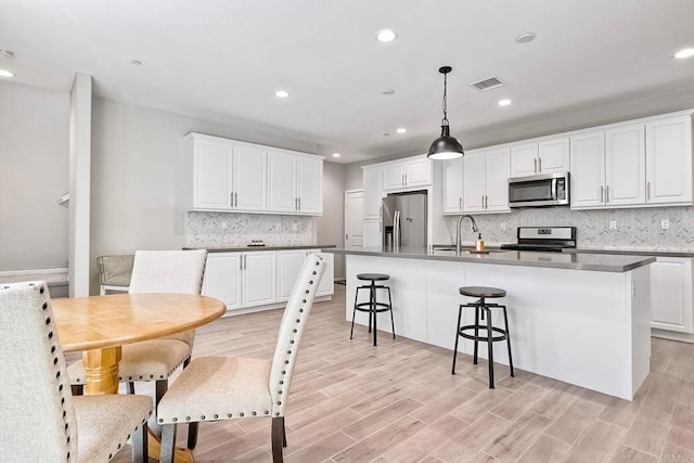 678 Gemstone Dr, San Marcos, CA 92078 - kitchen with stainless steel appliances, white cabinets, tasteful backsplash, an island with sink, and recessed lighting
