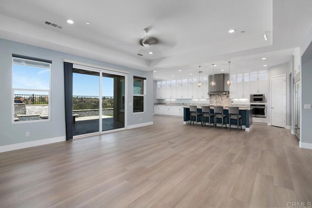 1733 Lemonadeberry Ln, Vista, CA 92084 - unfurnished living room featuring recessed lighting, baseboards, ceiling fan, light wood-style flooring, and a tray ceiling