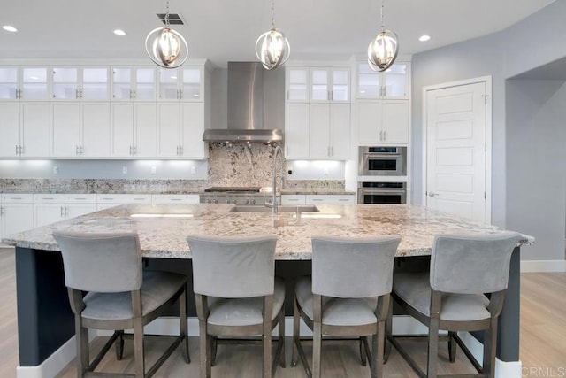 1733 Lemonadeberry Ln, Vista, CA 92084 - kitchen with wall chimney exhaust hood, a sink, stainless steel double oven, a center island with sink, and decorative backsplash