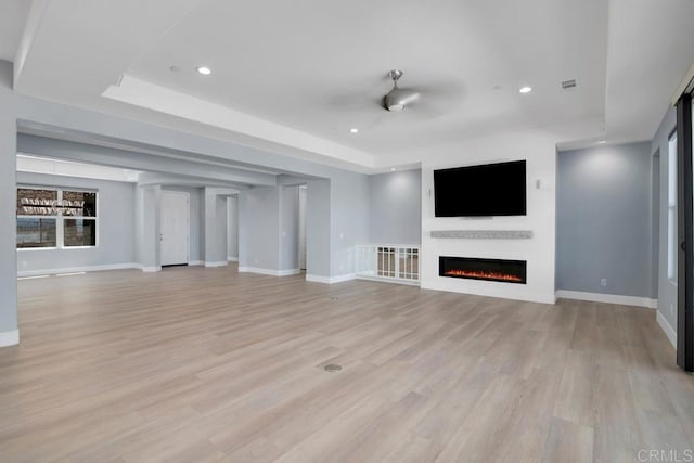 1733 Lemonadeberry Ln, Vista, CA 92084 - unfurnished living room featuring a lit fireplace, light wood-style floors, baseboards, recessed lighting, and a raised ceiling