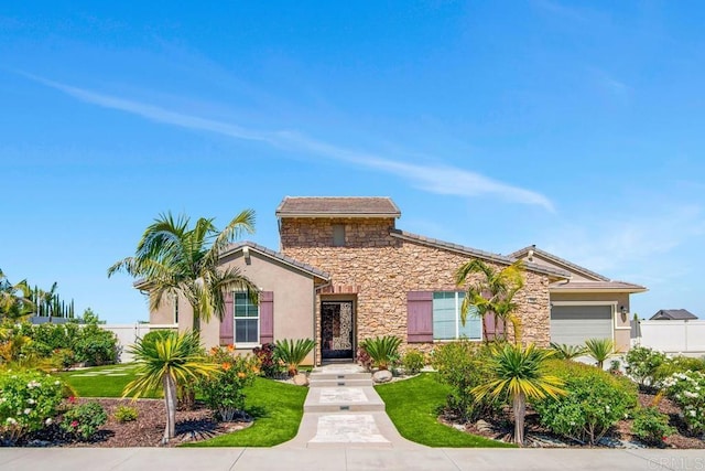 1733 Lemonadeberry Ln, Vista, CA 92084 - view of front facade with stone siding, an attached garage, stucco siding, and a front yard
