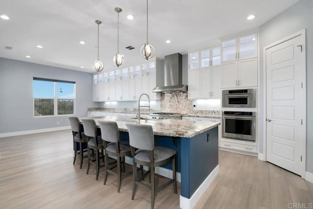 1733 Lemonadeberry Ln, Vista, CA 92084 - kitchen with wall chimney range hood, light wood-style floors, tasteful backsplash, white cabinetry, and recessed lighting
